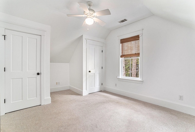 additional living space featuring light colored carpet, vaulted ceiling, and ceiling fan