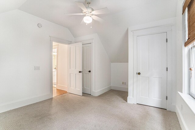 additional living space featuring ceiling fan, light colored carpet, and lofted ceiling