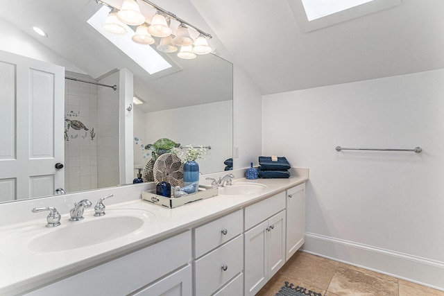 bathroom with lofted ceiling with skylight, vanity, and tiled shower