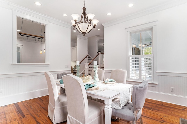 dining space with dark hardwood / wood-style floors, an inviting chandelier, and crown molding