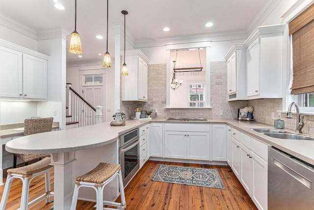 kitchen featuring white cabinets, pendant lighting, light wood-type flooring, and stainless steel appliances