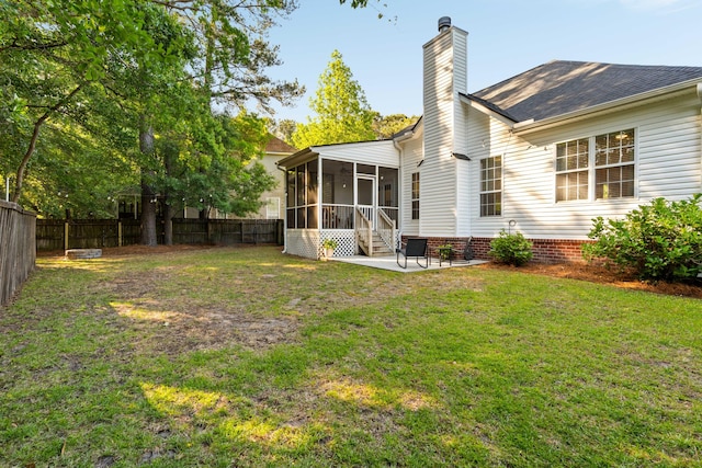 1971 N Smokerise Way, Mount Pleasant, SC 29466 - rear view of house featuring a sunroom, a fenced backyard, a chimney, a lawn, and a patio