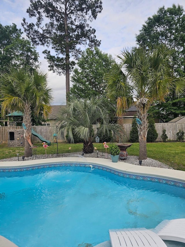 view of pool with a lawn