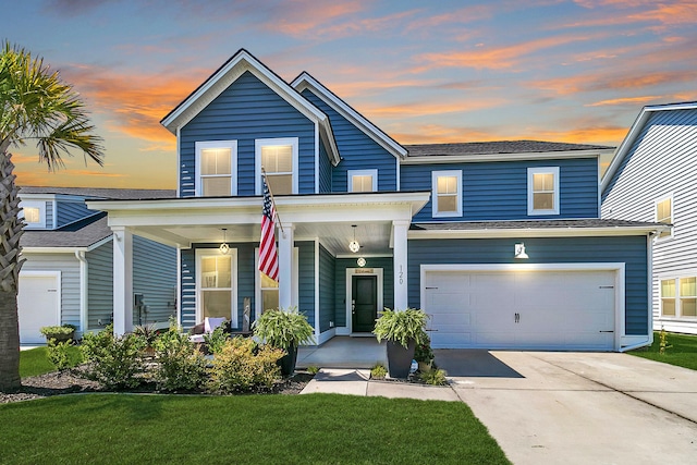 view of front of house with a lawn, a porch, and a garage