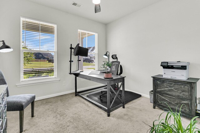 office area featuring plenty of natural light, ceiling fan, and light carpet