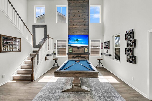 playroom with hardwood / wood-style floors, a high ceiling, and billiards