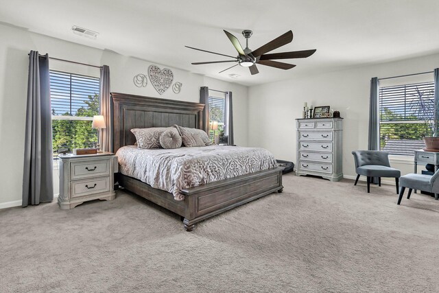 carpeted bedroom with ceiling fan and multiple windows