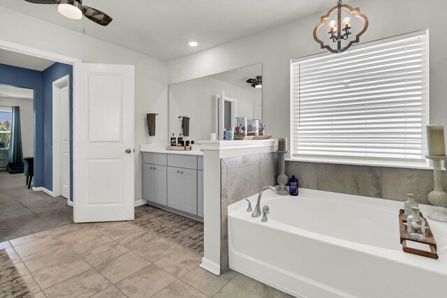 bathroom with a tub, ceiling fan, vanity, and tile patterned floors