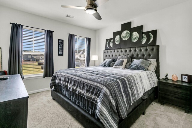 bedroom with ceiling fan, light carpet, and multiple windows