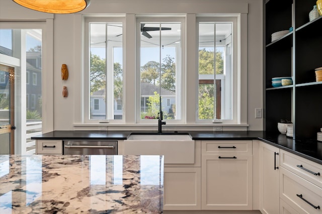 409 W Indian Ave, Folly Beach, SC 29439 - kitchen with dark stone counters, ceiling fan, white cabinets, dishwasher, and a sink