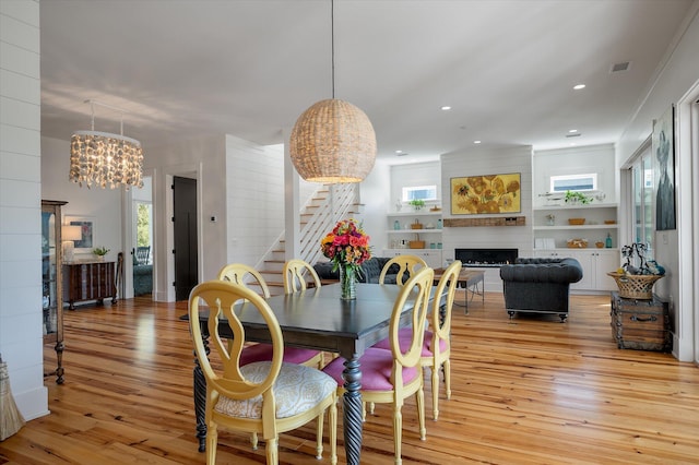 409 W Indian Ave, Folly Beach, SC 29439 - dining space with stairs, a fireplace, light wood-type flooring, and visible vents