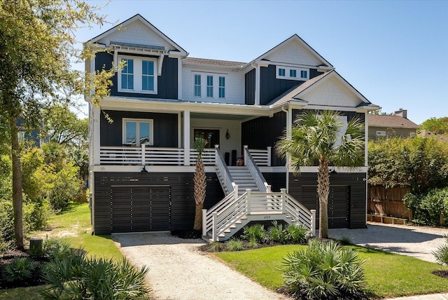 409 W Indian Ave, Folly Beach, SC 29439 - view of front of home featuring a porch, stairway, driveway, and fence