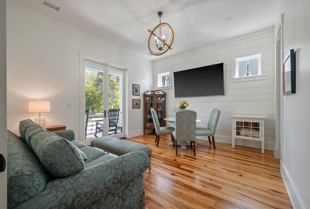 409 W Indian Ave, Folly Beach, SC 29439 - living room featuring baseboards, light wood finished floors, a notable chandelier, and visible vents