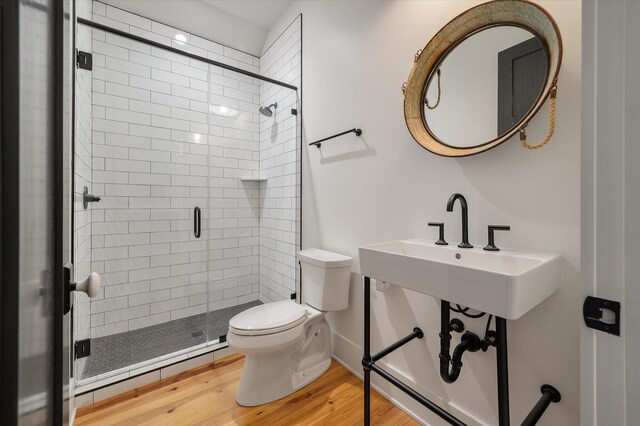 409 W Indian Ave, Folly Beach, SC 29439 - bathroom featuring a shower stall, baseboard heating, toilet, and wood finished floors