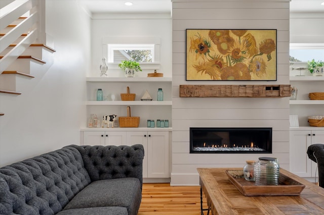 409 W Indian Ave, Folly Beach, SC 29439 - living room featuring a glass covered fireplace, recessed lighting, stairs, light wood-style floors, and a healthy amount of sunlight