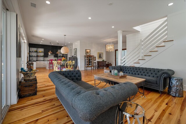 409 W Indian Ave, Folly Beach, SC 29439 - living room featuring visible vents, decorative columns, recessed lighting, stairs, and light wood-style flooring