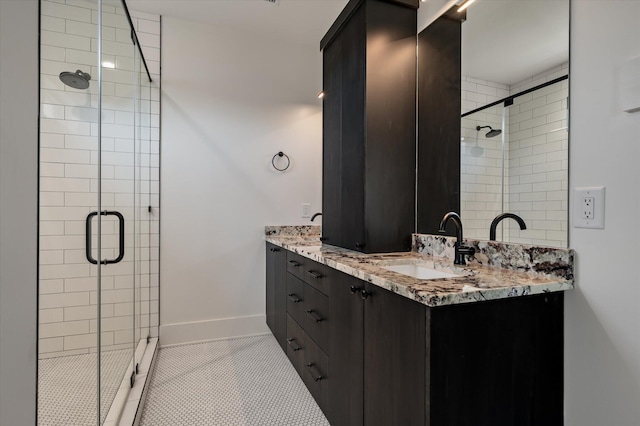 409 W Indian Ave, Folly Beach, SC 29439 - bathroom featuring baseboards, double vanity, a stall shower, tile patterned flooring, and a sink
