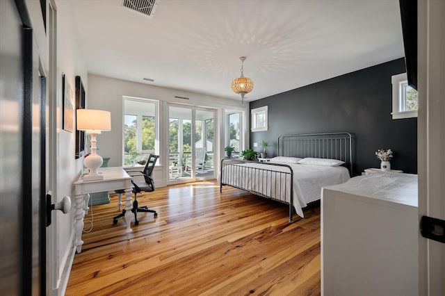 409 W Indian Ave, Folly Beach, SC 29439 - bedroom with access to exterior, multiple windows, visible vents, and hardwood / wood-style flooring