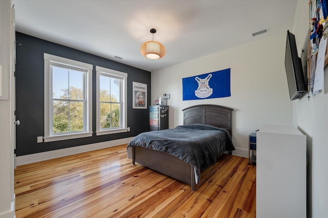 409 W Indian Ave, Folly Beach, SC 29439 - bedroom with light wood-style floors, visible vents, and baseboards