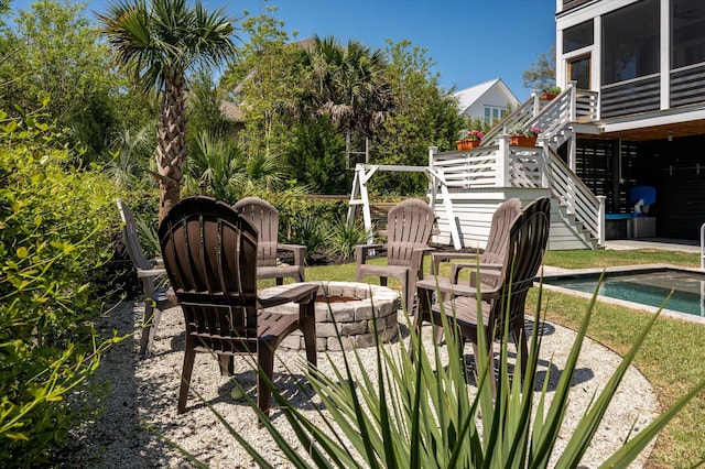 409 W Indian Ave, Folly Beach, SC 29439 - view of patio / terrace with stairway, an outdoor pool, a sunroom, and an outdoor fire pit