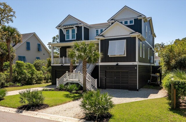 409 W Indian Ave, Folly Beach, SC 29439 - raised beach house with stairs, a front lawn, an attached garage, and dirt driveway