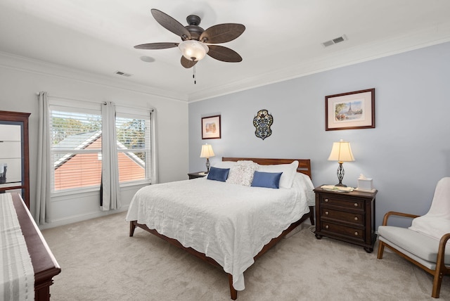 carpeted bedroom with ornamental molding and ceiling fan