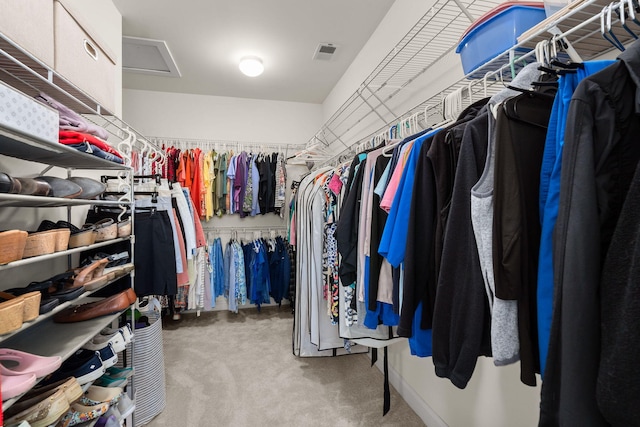 walk in closet featuring light colored carpet