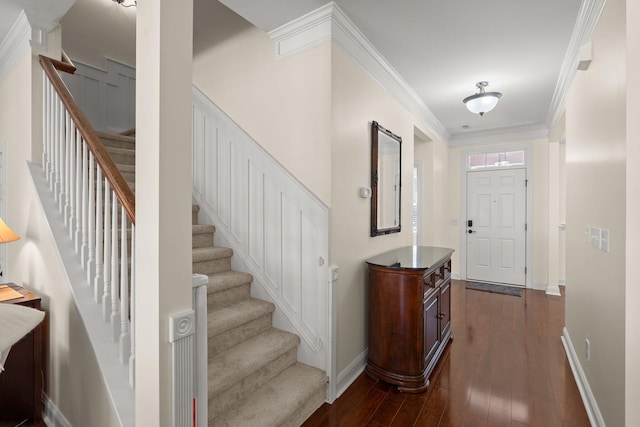 foyer with ornamental molding and dark hardwood / wood-style floors