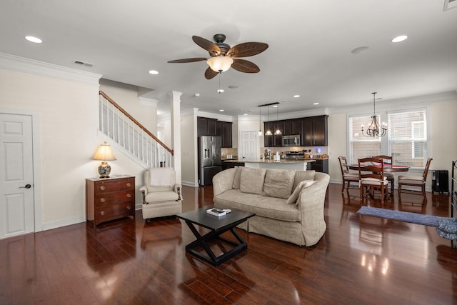 living room with dark hardwood / wood-style flooring, ceiling fan with notable chandelier, and ornamental molding