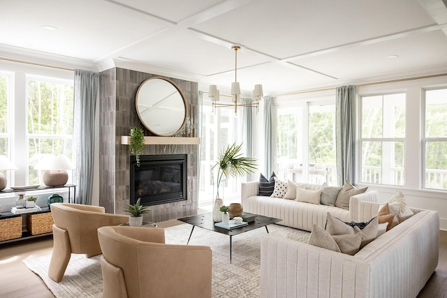 sunroom with a tiled fireplace, an inviting chandelier, and coffered ceiling