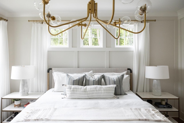 bedroom with a decorative wall and an inviting chandelier