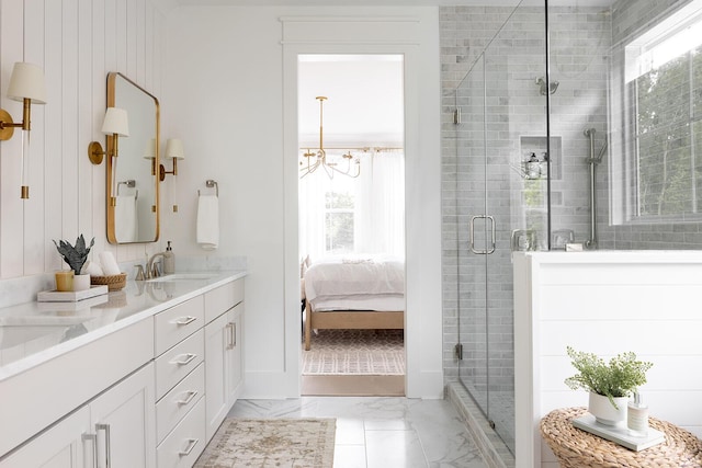 bathroom with a sink, marble finish floor, a stall shower, and double vanity