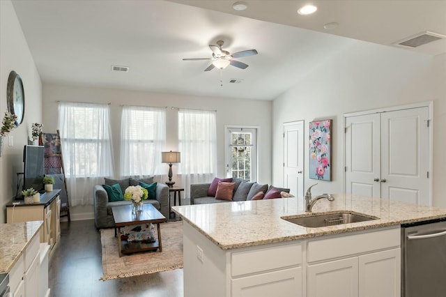 kitchen featuring dishwasher, light stone countertops, sink, and white cabinets