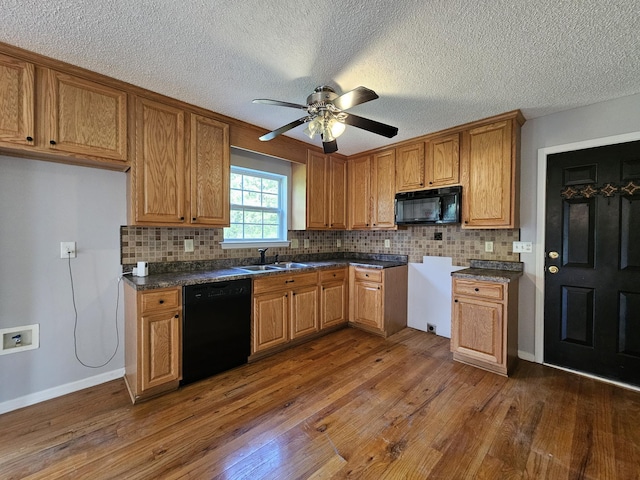 3564 Elliott Rd, Pinewood, SC 29125 - kitchen with black appliances, a sink, brown cabinets, dark wood finished floors, and a textured ceiling