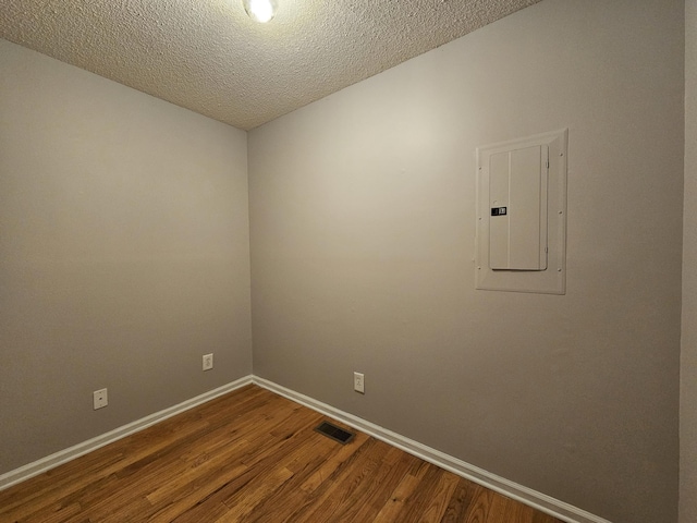 3564 Elliott Rd, Pinewood, SC 29125 - unfurnished room featuring electric panel, wood finished floors, baseboards, and a textured ceiling