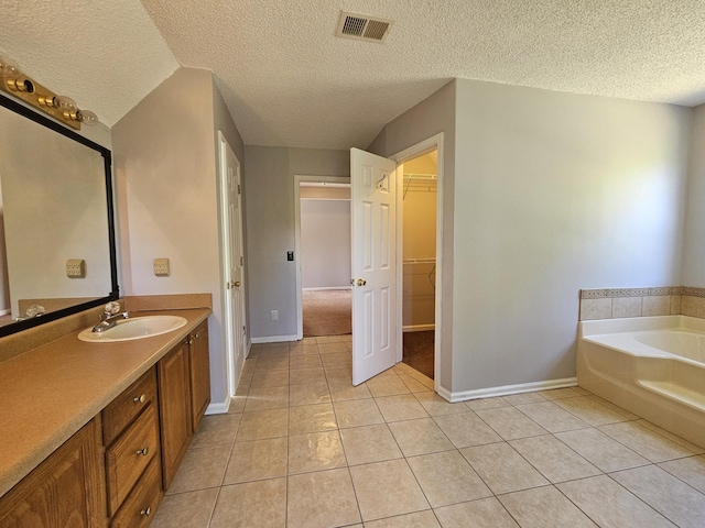 3564 Elliott Rd, Pinewood, SC 29125 - bathroom with a textured ceiling, tile patterned flooring, baseboards, a bath, and vanity