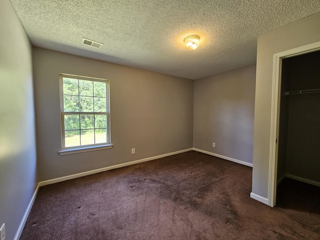 3564 Elliott Rd, Pinewood, SC 29125 - unfurnished bedroom with dark carpet, a textured ceiling, a closet, and baseboards