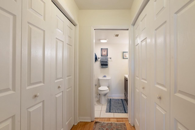 bathroom with wood-type flooring, vanity, and toilet