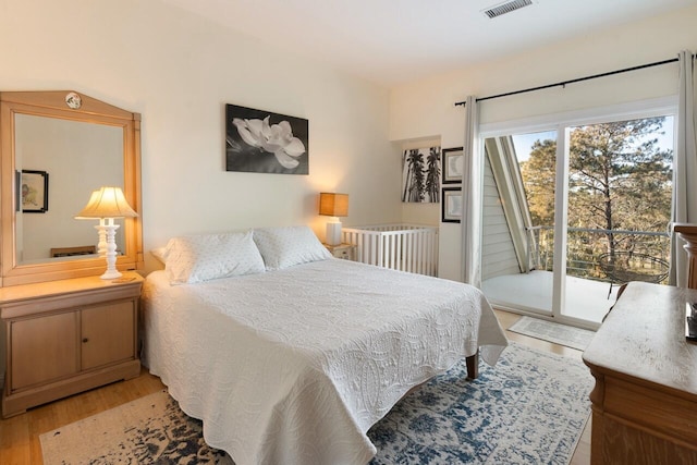 bedroom with light wood-type flooring and access to outside