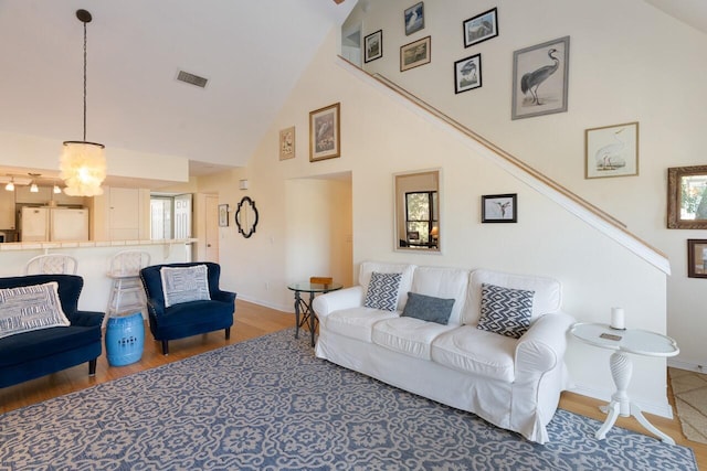 living room featuring hardwood / wood-style floors, plenty of natural light, and high vaulted ceiling