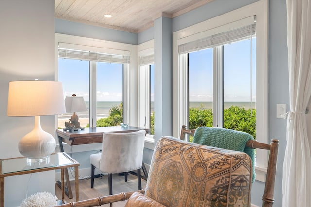 dining space with wood-type flooring, a water view, ornamental molding, and wooden ceiling