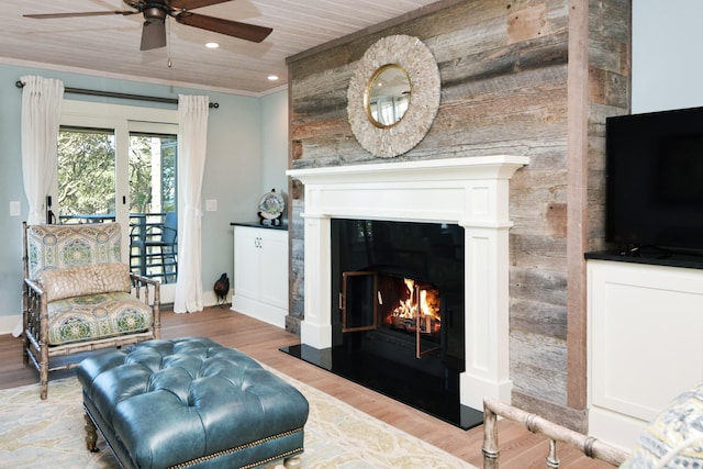 living room with ceiling fan, hardwood / wood-style floors, wood ceiling, and ornamental molding