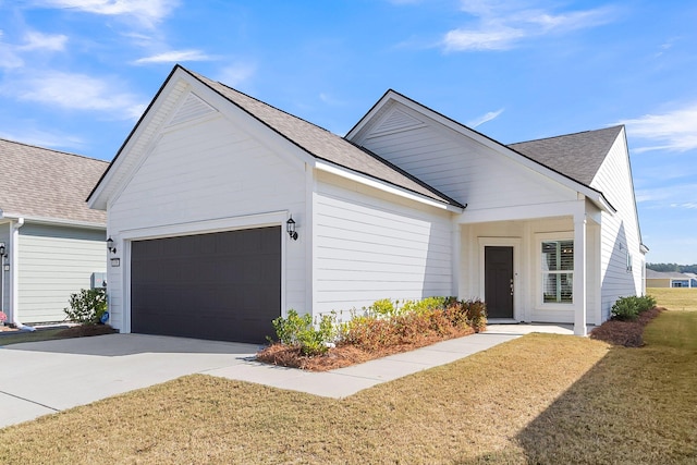 view of front of home with a front yard and a garage