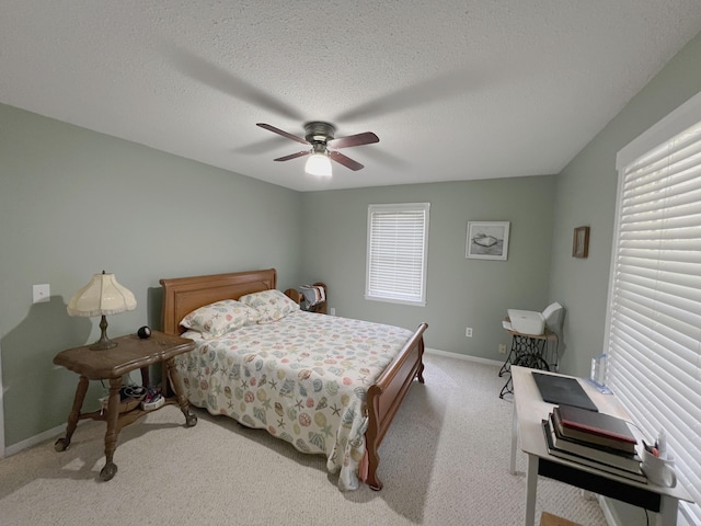 bedroom featuring light carpet, baseboards, ceiling fan, and a textured ceiling
