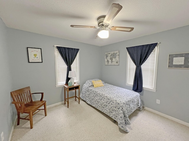 bedroom with baseboards, a textured ceiling, multiple windows, and ceiling fan