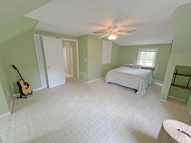 bedroom featuring visible vents, lofted ceiling, carpet flooring, and a ceiling fan