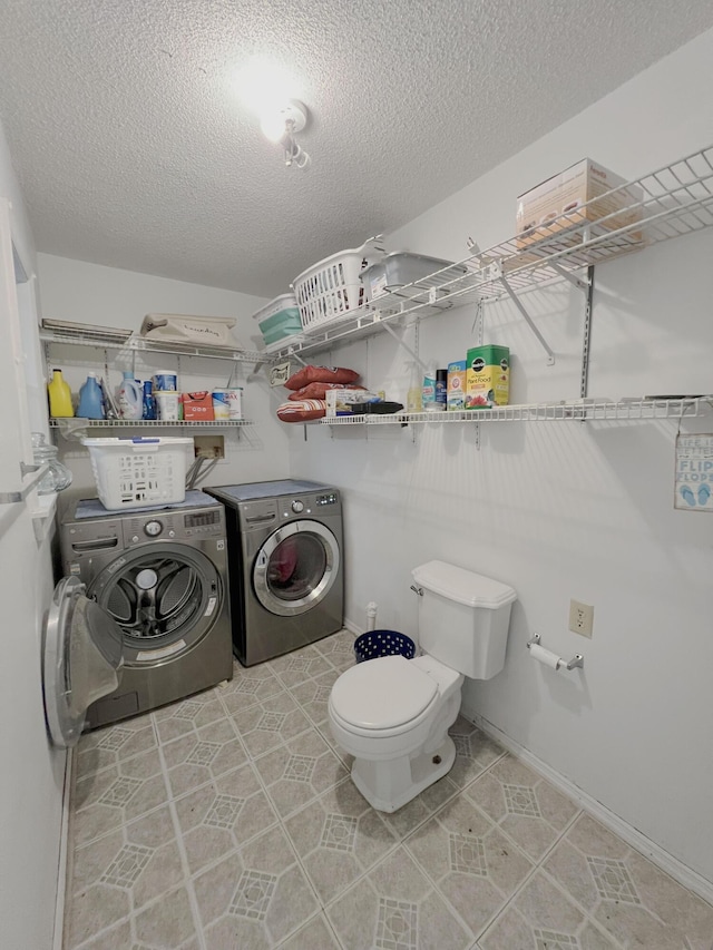 clothes washing area featuring a textured ceiling and washer and clothes dryer