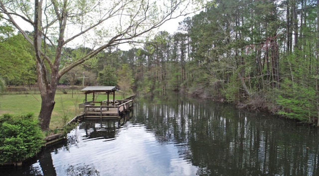 dock area with a water view and a wooded view
