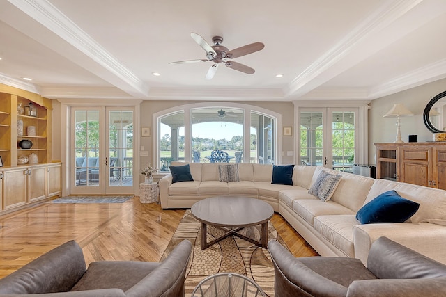 living room featuring ceiling fan, french doors, plenty of natural light, and a raised ceiling