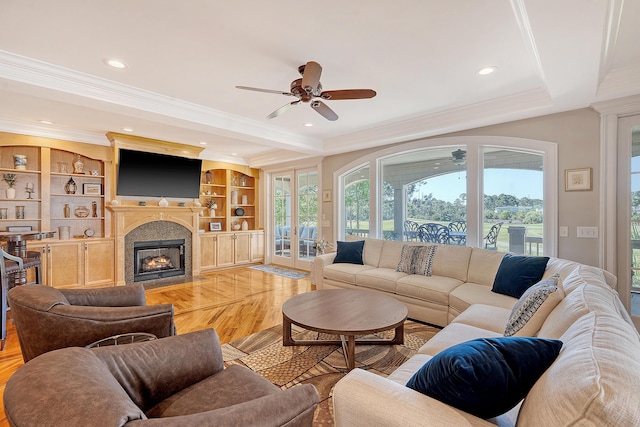 living room with a fireplace with flush hearth, light wood-type flooring, recessed lighting, a ceiling fan, and crown molding